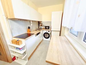 a small kitchen with white cabinets and a sink at Kodó Apartman in Székesfehérvár