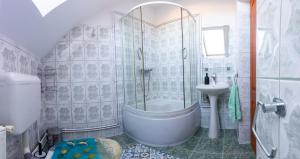 a bathroom with a shower and a tub and a sink at Írisz Vendégház in Lăzarea +27 photos