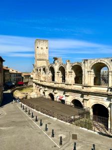 an old building with a clock tower in a city at Appartement aux Arènes in Arles +11 photos