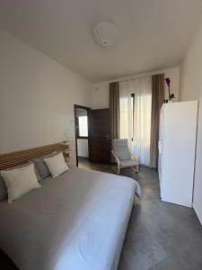 a bedroom with a large white bed and a chair at Suite con jacuzzi in pieno centro in Benevento +11 photos