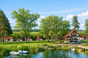 a river with boats in front of a house at Вили Янкови in Dobri Dyal