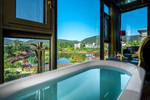 a bath tub in a room with a window at Zishui Qinglu Manor in Sanya