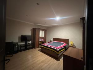 a bedroom with a bed and a desk and a television at Marikuna in Gori