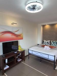 a room with a bed and a flat screen tv at City View Studio Chmielna in Warsaw