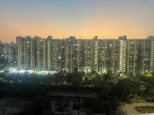 a large city with tall buildings at night at Aayu's Home 74 in Noida