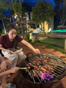 a man is cooking food on a grill at Moc Homestay & Villa in Cư Chinh