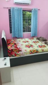 a bedroom with a bed with a floral bedspread at Avani homestay in Subrahmanya