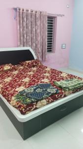 a bed in a room with a bed frame with a blanket at Avani homestay in Subrahmanya