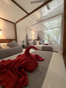 a red towel laying on a bed in a room at Flower Resort Ella in Ella