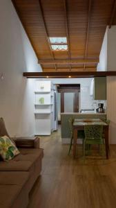a living room with a table and a kitchen at Saint Germain - Lagoa da Conceição in Florianópolis