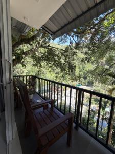 a balcony with a table and a bench and a tree at Flower Resort Ella in Ella