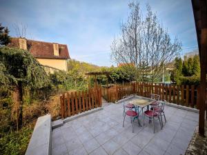 a patio with a table and chairs and a fence at Vaucorbe - Bail Partner in Roffey +17 photos