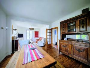 a living room with a table and a large wooden cabinet at Vaucorbe - Bail Partner in Roffey
