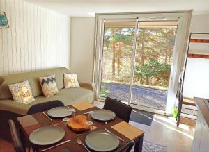 a living room with a table and a couch at Les Apparts du Vignal de Cheyrac in Polignac