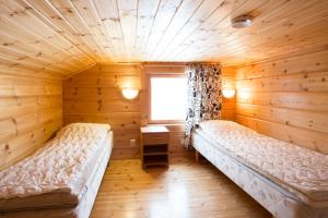a room with two beds in a log cabin at Kelkkakoivu in Jämsä