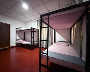two bunk beds in a room with red floors at Niwasa Habarana in Habarana