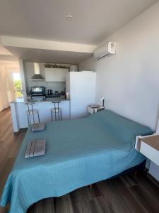 a bedroom with a blue bed and a kitchen at La Raquel in La Plata +2 photos