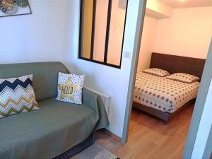 a living room with a couch and a bed at Les Apparts du Vignal de Cheyrac in Polignac +41 photos