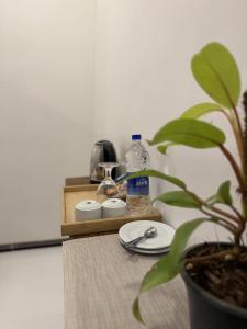 a table with a plate and a bottle of water and a plant at Flower Resort Ella in Ella