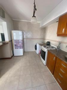 a kitchen with a stove and a white refrigerator at Casa Colibrí zona Parque Saavedra de La Plata in La Plata +3 photos