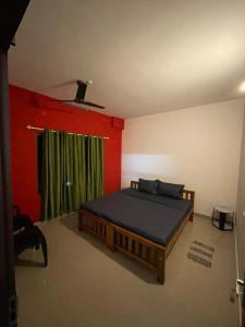 a bedroom with a bed and a green curtain at Southern Cliff House in Varkala