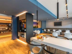 a dining room and kitchen with a table and chairs at B&B Hotel Düsseldorf-City in Düsseldorf