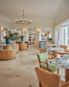 a restaurant with tables and chairs and a bar at Villa Sant'Andrea, A Belmond Hotel, Taormina Mare in Taormina
