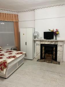 a white bedroom with a bed and a fireplace at Caterine lodge in Whetstone