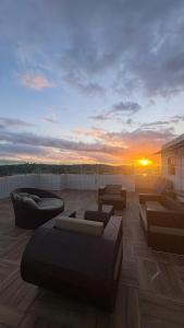 a rooftop patio with couches and a sunset at Freedom Rooftop - Temos Wallbox 7kW para EV in Garanhuns