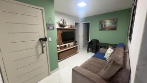 a living room with a couch and a flat screen tv at Freedom Rooftop - Temos Wallbox 7kW para EV in Garanhuns