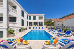 a villa with a swimming pool and lounge chairs at Villa Slano in Slano