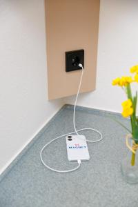a scale on the floor next to a vase of flowers at Magnet Hotel in Schkeuditz