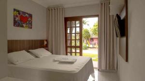 a bedroom with a bed and a sliding glass door at Saint Germain - Lagoa da Conceição in Florianópolis +182 photos