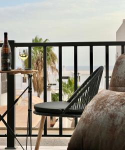 a chair sitting on a balcony with a glass of wine at Canaryislandshost l Balcón del Mar in Puerto del Carmen