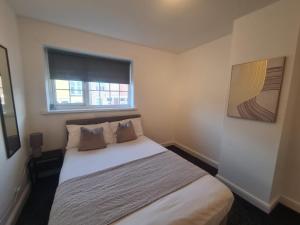 a small bedroom with a bed with a window at Stylish 3 bed close to Nissan in Sunderland +23 photos