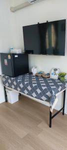 a bed in a room with a tv on top at วันรีสอร์ท in Ratchaburi