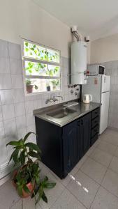 a kitchen with a sink and a refrigerator and a window at La casita in Río Cuarto +3 photos