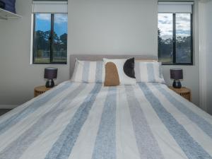 a bedroom with a large bed with two windows at The French River Chalets in Kalgan