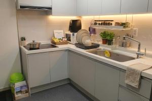 a kitchen with white cabinets and a sink at Ara Guesthouse in Busan +8 photos
