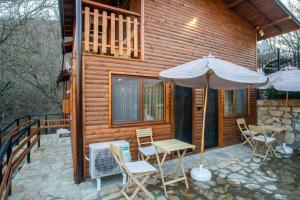 a cabin with a table and chairs and an umbrella at Green View 2 in Skrino
