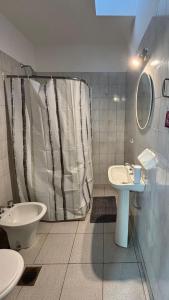 a bathroom with a shower and a sink and a toilet at La casita in Río Cuarto