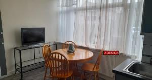 a kitchen with a table and chairs and a television at Parkside Studio in Luton