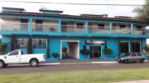 a blue building with a truck parked in front of it at Paulos Pousada in Lagoa Santa