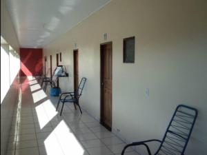 an empty hallway with chairs and a tv on the wall at Paulos Pousada in Lagoa Santa