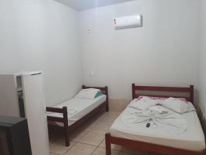 two beds in a small room with at Paulos Pousada in Lagoa Santa