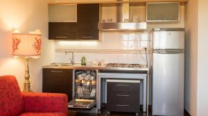 a kitchen with a stove and a refrigerator at Stintino Apartments in Stintino
