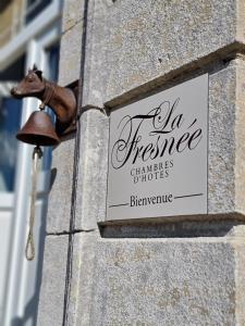 a sign on the side of a building with a horse statue at La Fresnée chambres d'hôtes in Mosles