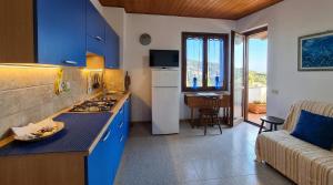 a kitchen with blue cabinets and a kitchen with a couch at Stintino Apartments in Stintino +18 photos