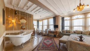 ein großes Badezimmer mit Badewanne und Sofa in der Unterkunft Kitapevi Hotel in Bursa