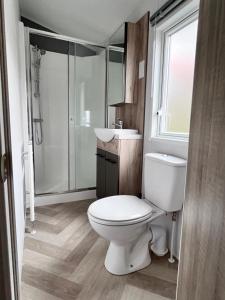 a bathroom with a toilet and a sink and a shower at B&B Voor De Zee in Westerland
